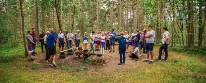 Suur grupp inimesi on kogunenud rohelises metsas asuva gaasilätte ümber.